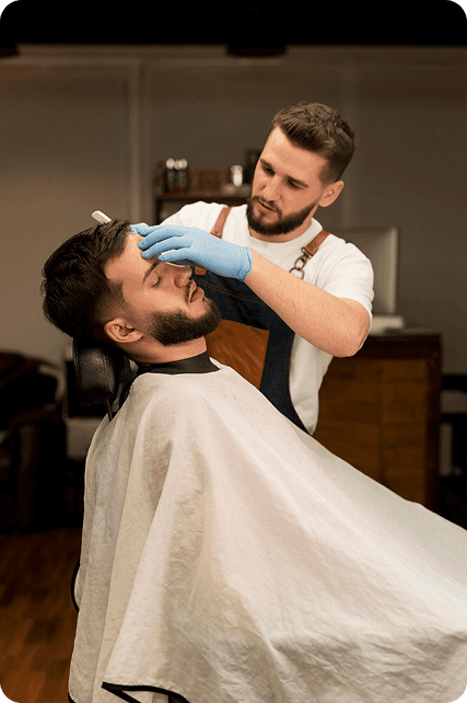 Barber applying hair treatment to a client