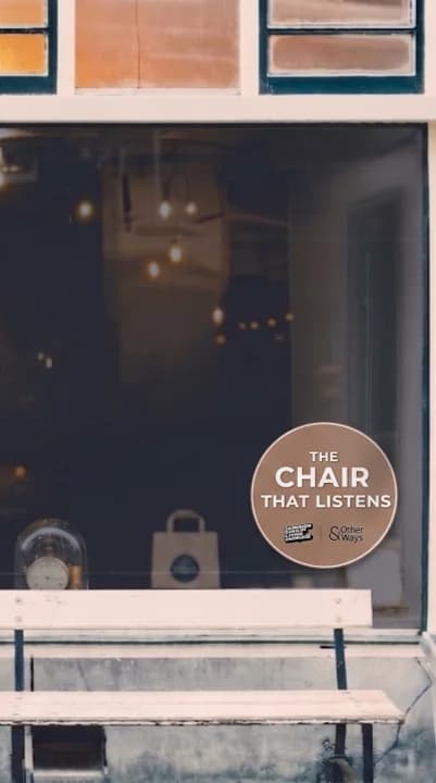A barbershop storefront with a The Chair That Listens sticker in the window.